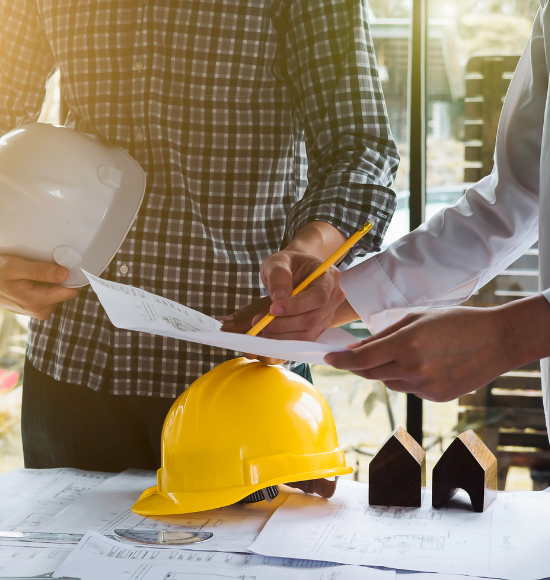 2 individuals looking over construction blueprints