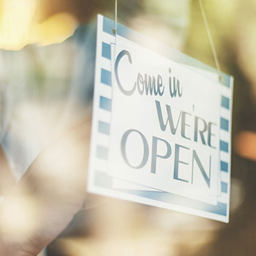 Sign reading "Come in, We're Open" on the door of a business.