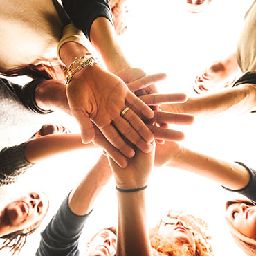 Group of people with hands together.